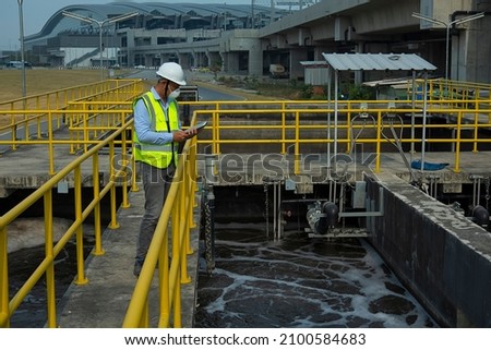 Wastewater treatment concept. Service engineer on  waste water Treatment plant. Royalty-Free Stock Photo #2100584683