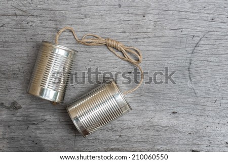 tins telephone with rope connecting on wooden background Royalty-Free Stock Photo #210060550