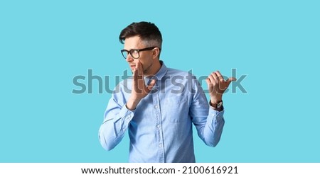 Gossiping man on color background Royalty-Free Stock Photo #2100616921
