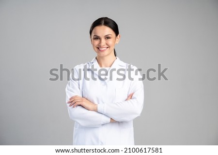 Photo of young happy woman professional wearing suit smiling friendly while posing arms crossed to the camera isolated on grey color background  Royalty-Free Stock Photo #2100617581