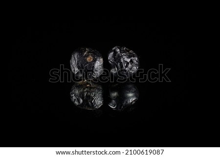 A closeup of two Metallic Asteroid 3D Rendering reflecting Over a shiny Black Background