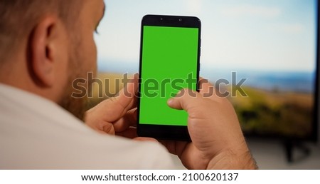 Man Using Smartphone with Green Screen for Copy Space Close up Chroma Key Mockup. Scrolling Gestures. Male watching gadget green screen and touch display.