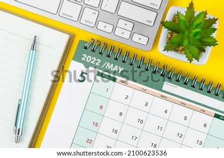 May 2022 desk calendar and diary with keyboard computer on yellow background. Royalty-Free Stock Photo #2100623536
