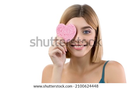 Beauty model cleansing her perfect skin and cover her eye by heart shape pad sponge, . Young woman cares about her face. Spa and Wellness, Skin Care Concept.