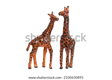 Couple of giraffes in love. Toy souvenir figurine for interior, isolated on white background.