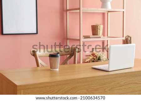 Interior of modern room with workplace near color wall