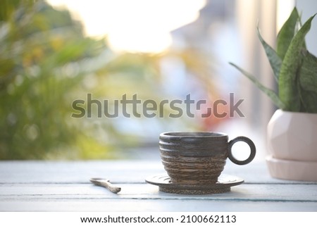 Palm cup and spoon with snake plant on blue wooden table