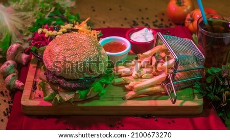 Besides the hamburger menu presented on the table, black pepper, sauces, tomatoes, mushrooms, tray and table cloth are placed as decorations with neon light

 Royalty-Free Stock Photo #2100673270