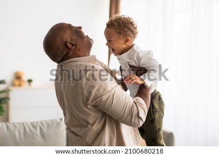 Best Grandpa. Joyful Black Grandfather Lifting His Little Grandson Holding Him In Arms Having Fun At Home. Senior Grandparent Playing With Grandchild On Weekend. Happy Family Moments Royalty-Free Stock Photo #2100680218