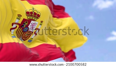 The national flag of Spain waving in the wind on a clear day. Selective focus. Realistic 3D seamless animation. Royalty-Free Stock Photo #2100700582