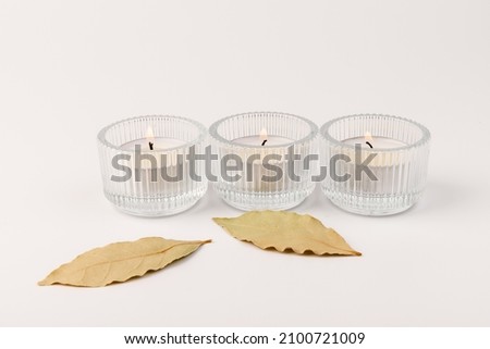 Scented candles with a dry leaf on a white background. Space for text.
