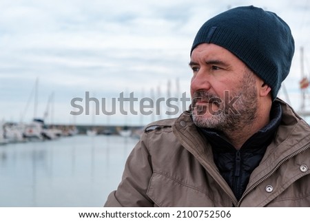 Baby Boomer Man With winter hat looking out to sea