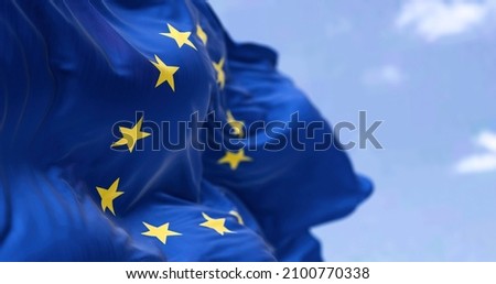 The flag of The European Union flapping in the wind. Economic and finance Community. Politics and Economy. Transnational political government Royalty-Free Stock Photo #2100770338