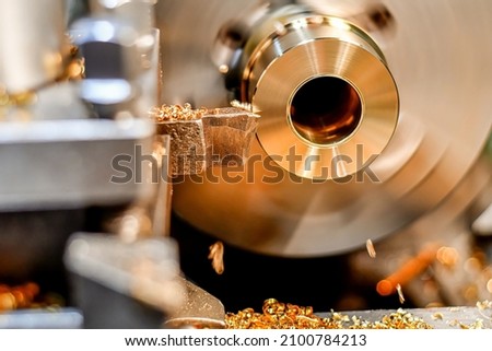 A turner makes a bronze bushing on a lathe by removing chips with a mechanical cutter. Royalty-Free Stock Photo #2100784213