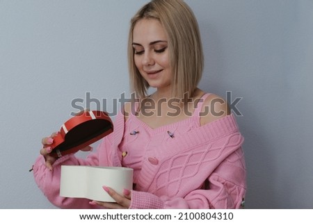 Girl holding a gift in the shape of a heart. The concept of the holiday, Valentine's Day, birthday, women's day, 14 February