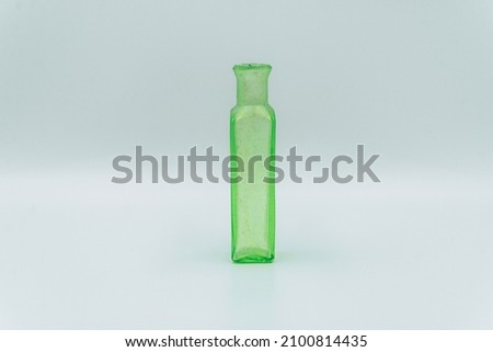 antique small green glass bottle on white background