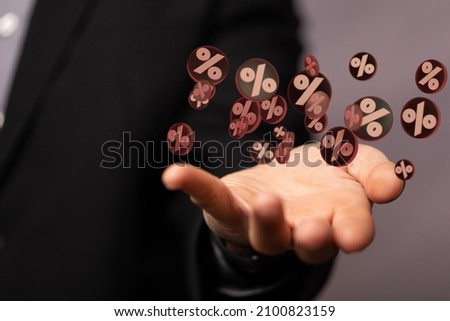 A male's hand holding an illustration of a bunch of brown and white percent signs