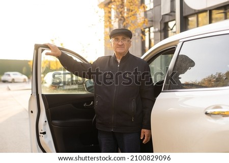 Smiling happy elderly man in the new car