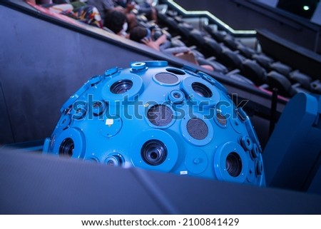 A closeup of a planetarium projector with people enjoying the experience in the background Royalty-Free Stock Photo #2100841429