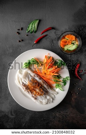 banh kuon, vietnamese steamed rice pancakes stuffed with pork, mushroom, onion. concept of asian street food, top view Royalty-Free Stock Photo #2100848032