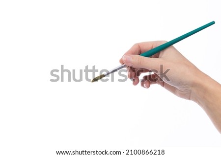 Art brush held in a lady's hand, on a white background