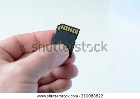 Man hand holds Memory card - Flash card against white background.Concept photo , multimedia, photography,communication, gaming,  lifestyle.  copy space.