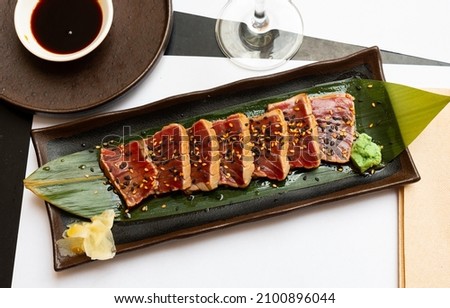 Delicious dish of Japanese cuisine tataki from tuna with an original ponzu sauce Royalty-Free Stock Photo #2100896044