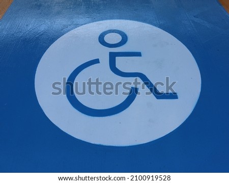 Sign blue painted on the pavement to mark a disabled parking space