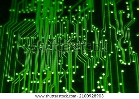 The picture shows a close-up of a green electronic circuit board and electrical lines that create a textured pattern.