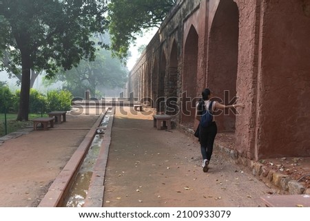 Traveler or tourist exploring historical structure of Humayun's tomb which is a UNESCO world heritage site situated in Delhi. History, geography, site seeing, architecture, archaeology, travel, study Royalty-Free Stock Photo #2100933079