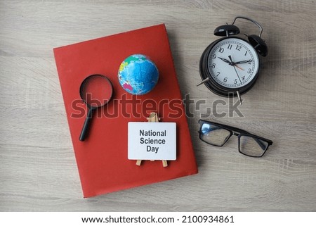 Flat lay of national science day writing on signboard with accesories on wooden background