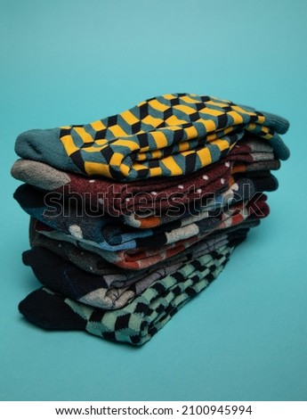 Studio photo of a bunch of colourful men's socks. The background is light blue.