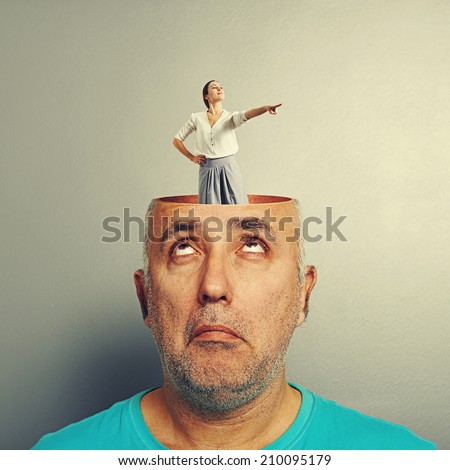 amazed senior man with open head. young smiley businesswoman standing in the head and showing the direction. photo over grey background