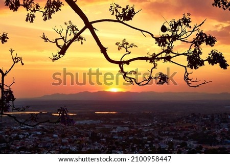 panoramic sunset horizontal picture with sun in the center and city in the shadows beautiful yellow and red sky in san miguel de allende guanajuato