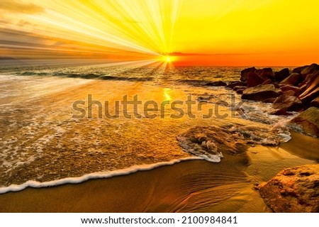 A Colorful Ocean Sunset With Sun Rays Emanating Over the Ocean Horizon Royalty-Free Stock Photo #2100984841