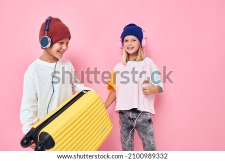 cute smiling kids with a yellow suitcase in his hands isolated background