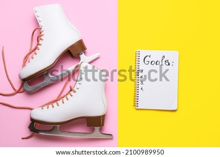 Notebook with empty to do list and ice skates on color background. New year goals