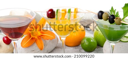 Composition with a orange, cherry and green vegetables cocktails