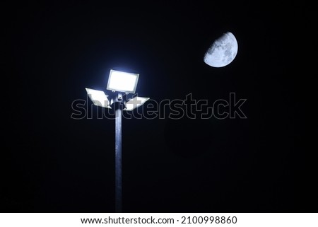 moon with the dark sky at night. solar cell led light pole with blue sky at night. Renewable Energy concept.