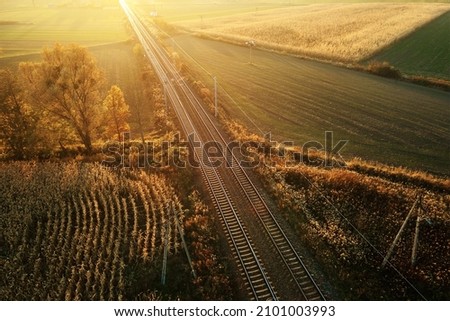 Aerial view of railway through agricultural fields at sunset, countryside landscape with railroad, bird eye view Royalty-Free Stock Photo #2101003993