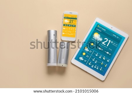 Weather forecast equipment and mobile phone with tablet computer on color background with space for text