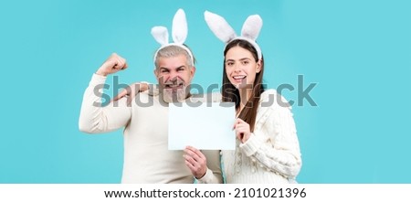 Easter couple dressed in costume holding blank white board for your text. Banner with funny bunny couple, copy space.