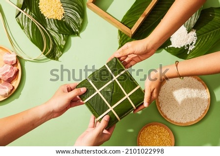Vietnamese traditional Chung cake with dong leaf pork glutinous rice in green background for holiday food advertising , top view Royalty-Free Stock Photo #2101022998