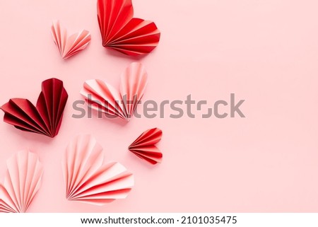 Paper hearts on pink background. Symbol of love for valentines day, happy birthday, greetings, Mothers day, Women's day. Origami.