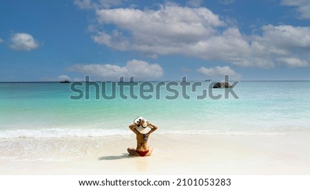 Relaxation with back view  young woman in red bikini  freedom lifestyle and happy on the sand  beach during summer vacation which under the sun tanning in a tropical beach-Summer concept