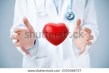 Female doctor hands holding a 3d illustration of red heart. Royalty-Free Stock Photo #2101068727