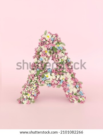 Creative letter A concept made of frash Spring wedding flowers. Flower font concept on pastel pink background.