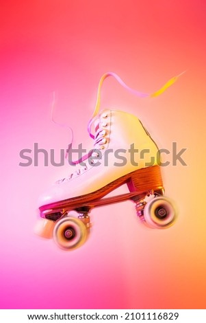 Classic white leather roller skate levitating on the vivid pink and orange background. Sports equipment and recreation. Dynamic pop art poster layout with free copy (text) space. Royalty-Free Stock Photo #2101116829