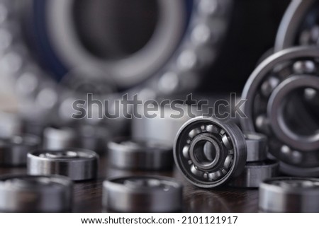 Steel bearing set. Ball radial and tapered plain bearings for mechanical engineering, heavy equipment and machine tools close-up. Spare parts in the form of round bearings of different sizes. Royalty-Free Stock Photo #2101121917