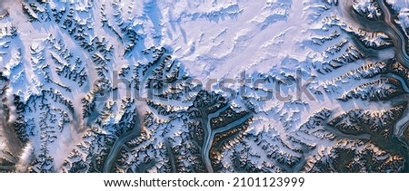 Shedding light on Greenland, satellite image, Greenland ice sheet and its edges, melt ponds, snowy mountain peaks cast long shadows in the evening sunlight. Elements of this image furnished by NASA
